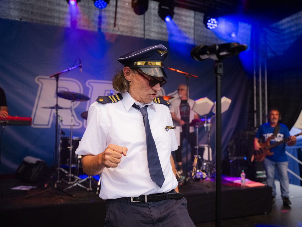 Lusthansa Mitglied in Piloten-Outfit bewegt sich zur Musik während einem Auftritt